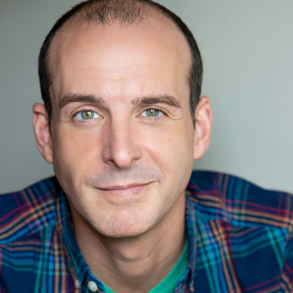 Actor Stephen Shellhardt in a flannel shirt in front of a gray backdrop