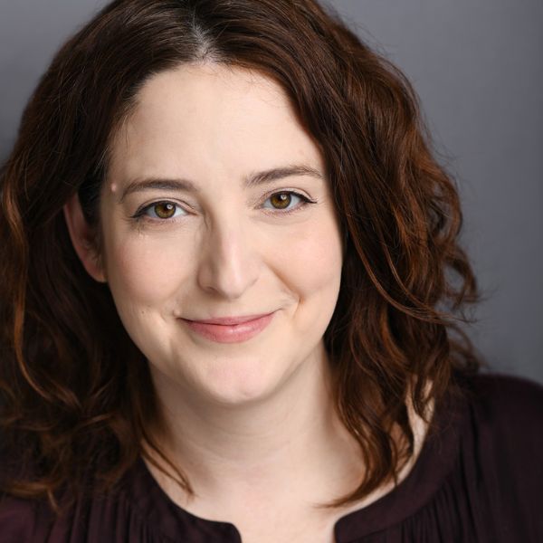 Actress Dara Cameron in a brown sweater in front of a gray backdrop