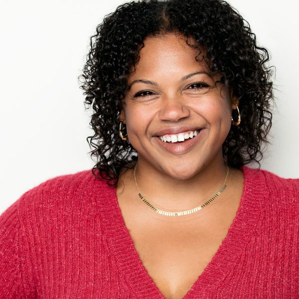 Headshot of actress Victoria Angelina Cruz in a red shirt in front of a white backdrop.