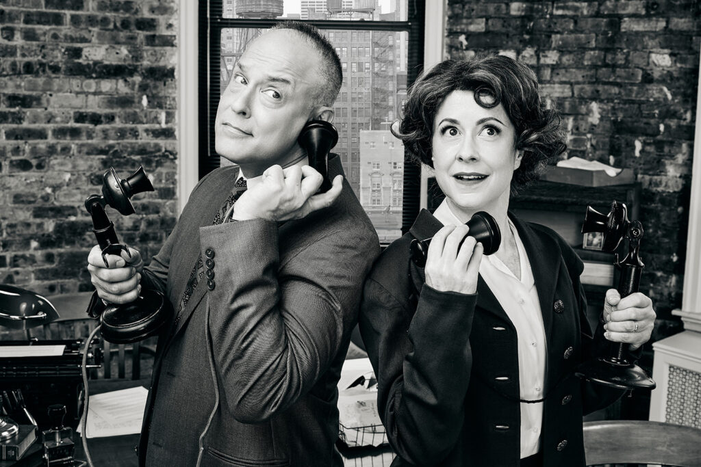 Actors Timothy Edward Kane and Kate Fry posed and holding telephones to their ears as they look over their shoulder at each other