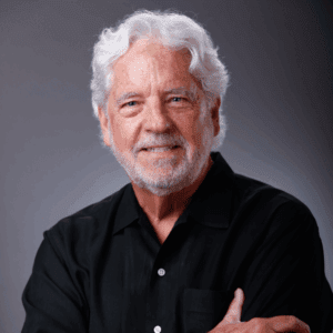 Tim in a black shirt posed in front of a gray backdrop
