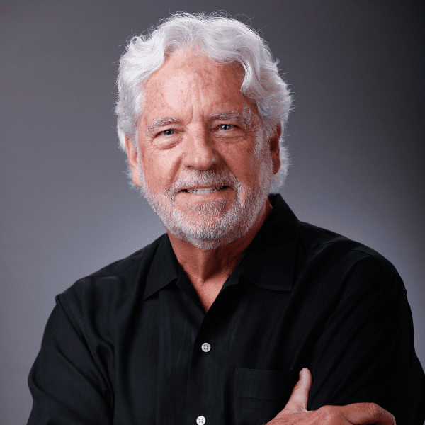 Tim in a black shirt posed in front of a gray backdrop