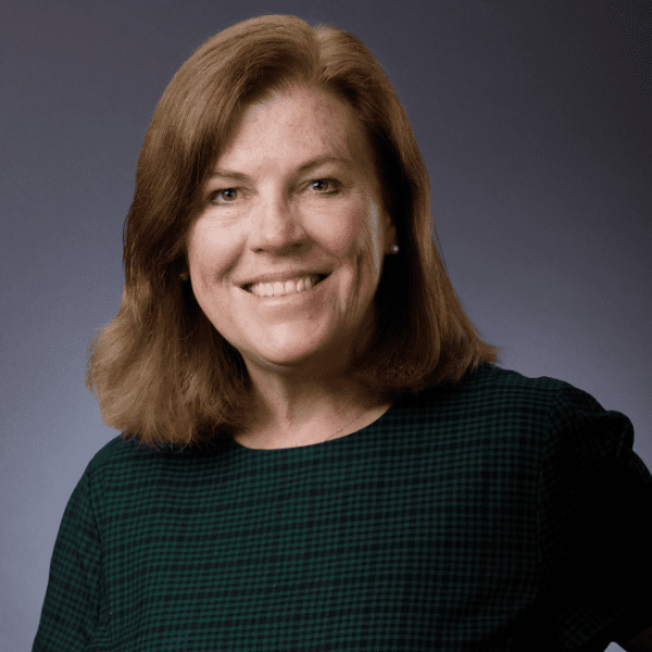 Kim in a black shirt posed in front of a gray backdrop.