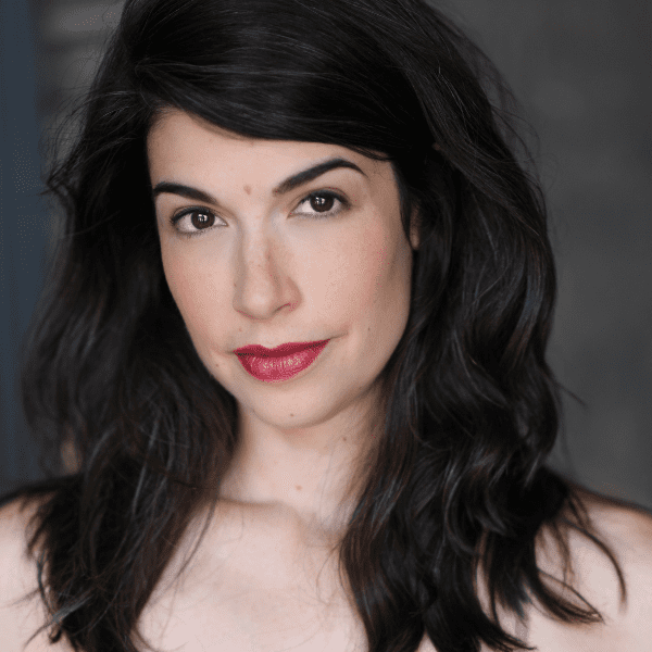 Actor Sarah Price posed in front of a gray backdrop